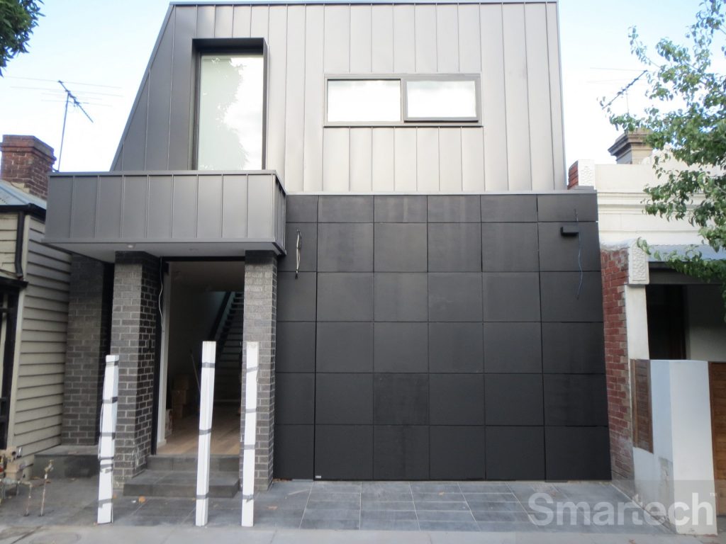 View of home near construction completion with the unique flush finish facade folding garage door