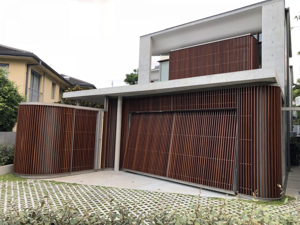 a Beautiful two storey home clad in a beautiful vertical timber featuring a flush finish facade garage door