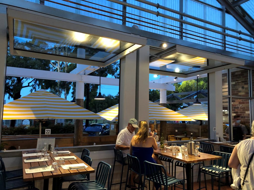 white tilt windows opened while diners enjoy dinner