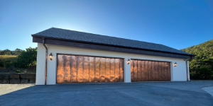 two garage doors clad in copper sheeting glistening in the sun.